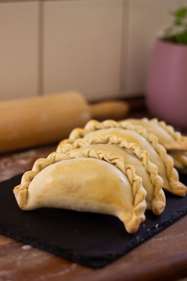 Empanadas crudas sobre pizarra oscura